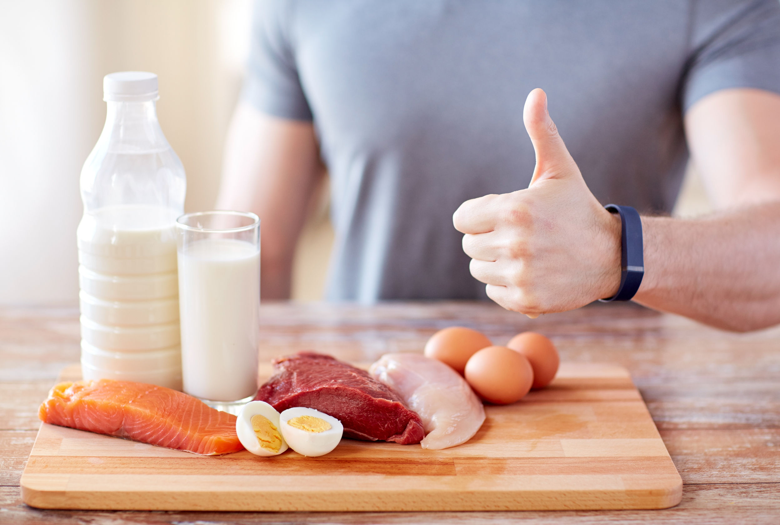 53578415 - sport, fitness, healthy lifestyle, diet and people concept - close up of man with food rich in protein showing thumbs up